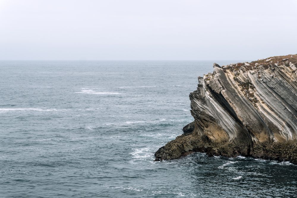 Rocky formations in the island of Baleal on the Atlantic coast in a foggy day. Peniche, Portugal