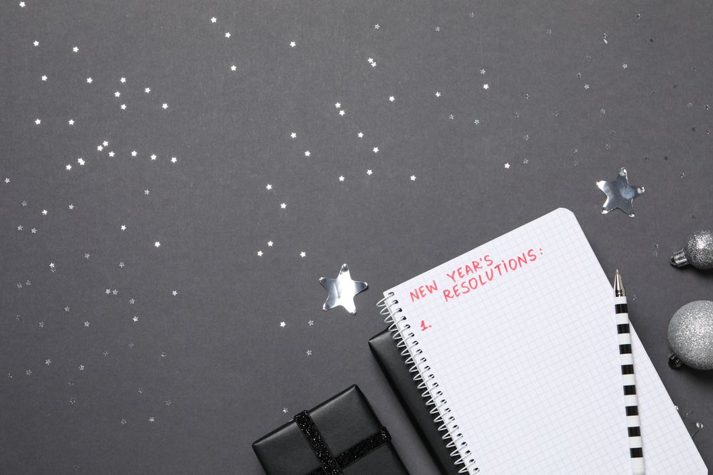 Gift boxes and notepad with list on gray background, space for text