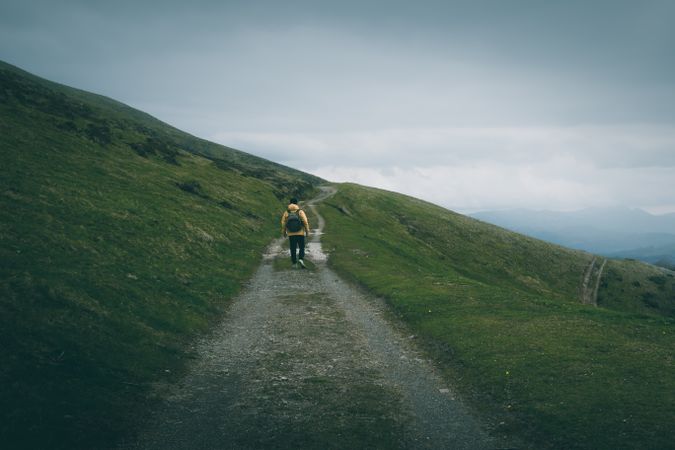 Anonymous traveler standing on road on hillside