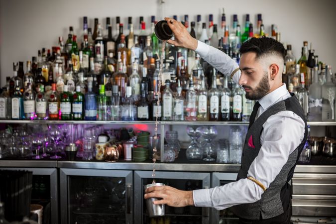 Bartender pouring a cocktail into shaker