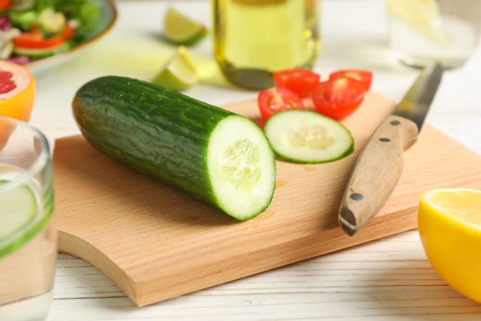 Ingredients for salad, kitchen supplies and oil on wooden background, close up