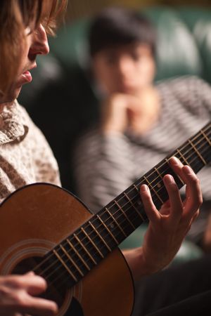 Young Musician Plays His Acoustic Guitar as Friend Listens