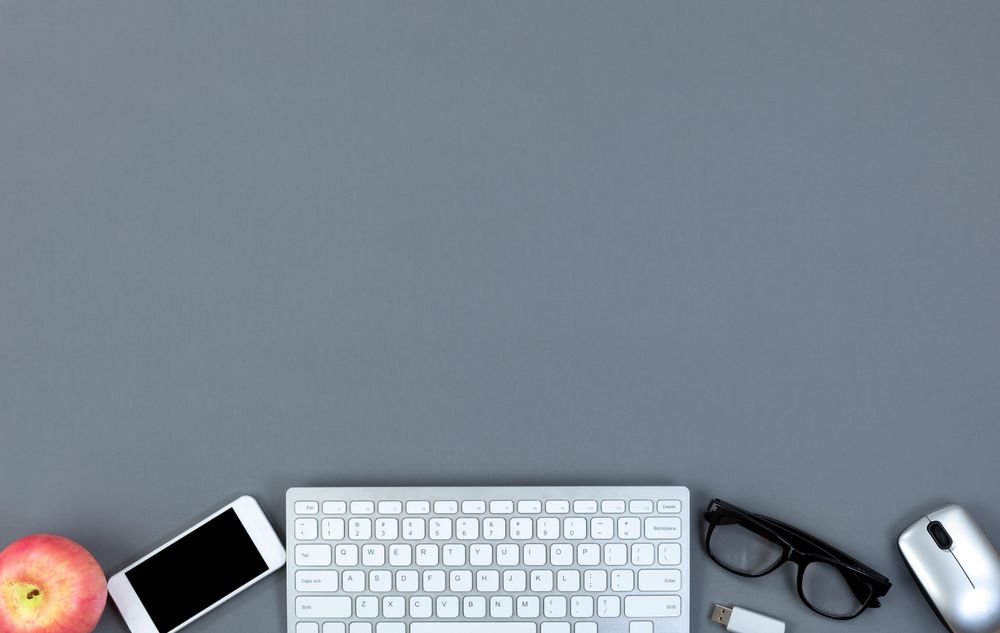 Clean gray office desktop with modern technology and apple fruit