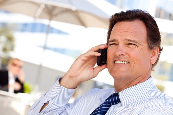Businessman Smiles as He Talks on His Cell Phone