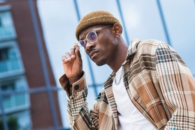 Stylish Black man resting on street
