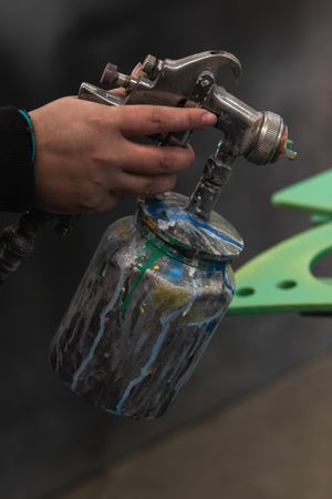 Crop master with paint gun in workshop