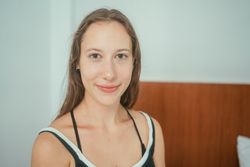 Woman sitting on bed smiling at camera
