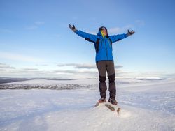 Man with arms up standing in the snow