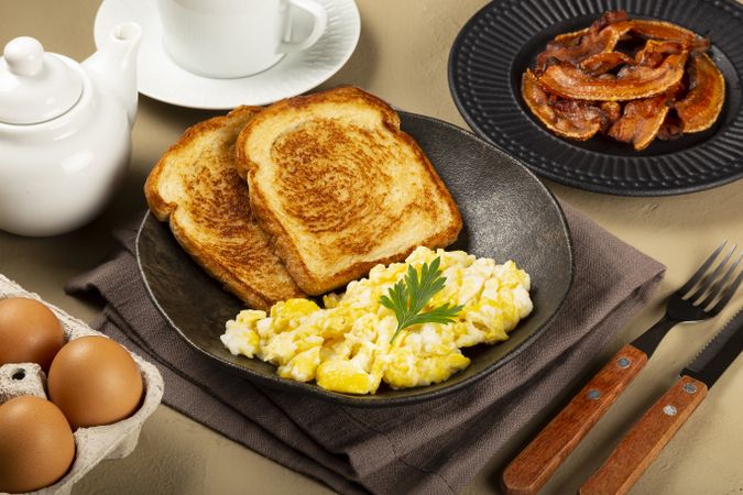 Breakfast. Scrambled egg with toast and bacon.