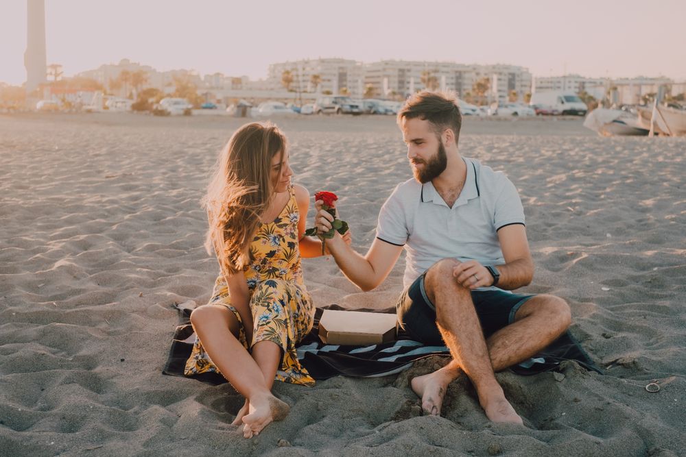 Lovely couple exchanging pleasantries on sandy shore