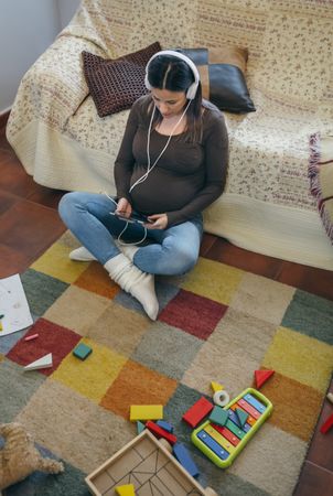 Pregnant using the tablet in the living room