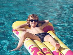 Glad boy spending time in swimming pool