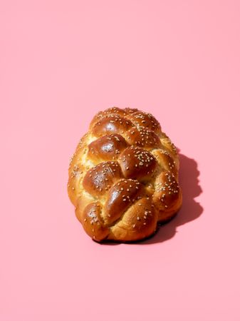 Homemade challah bread isolated on a pink background