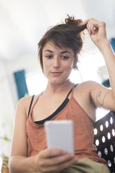 Inscrutable woman reading something on phone