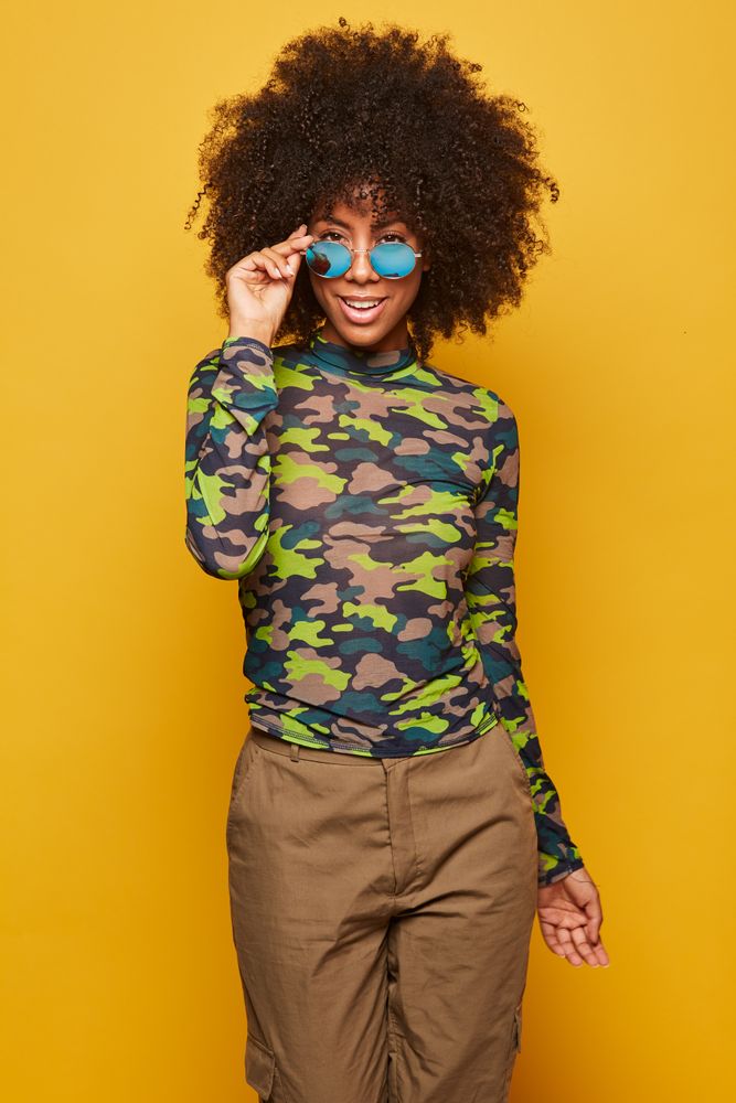Cool woman in sunglasses on bright backdrop