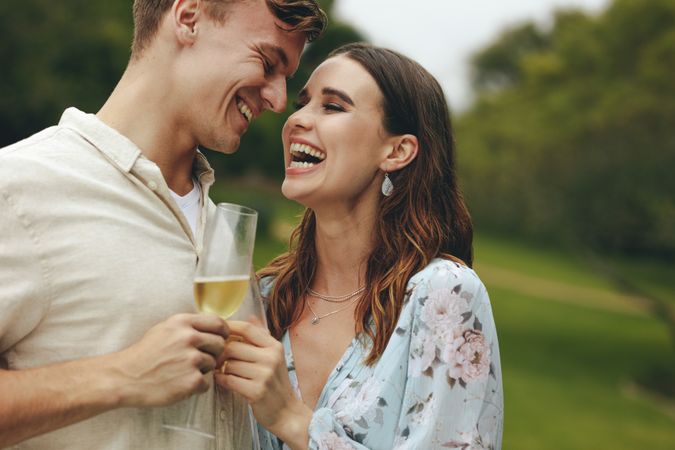 Loving young couple laughing while drinking champagne