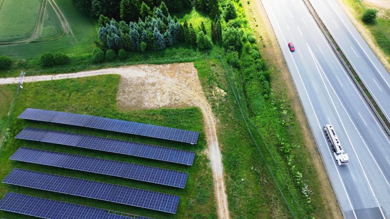 Aerial view of the A7 motorway in northern Germany with big solar panel areas close to the highway.