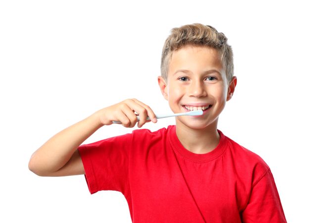 Boy in red t-shirt with toothbrush isolated on blank background
