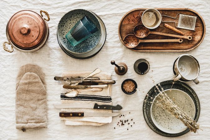 Vintage kitchen utensils artfully arranged on beige tablecloth