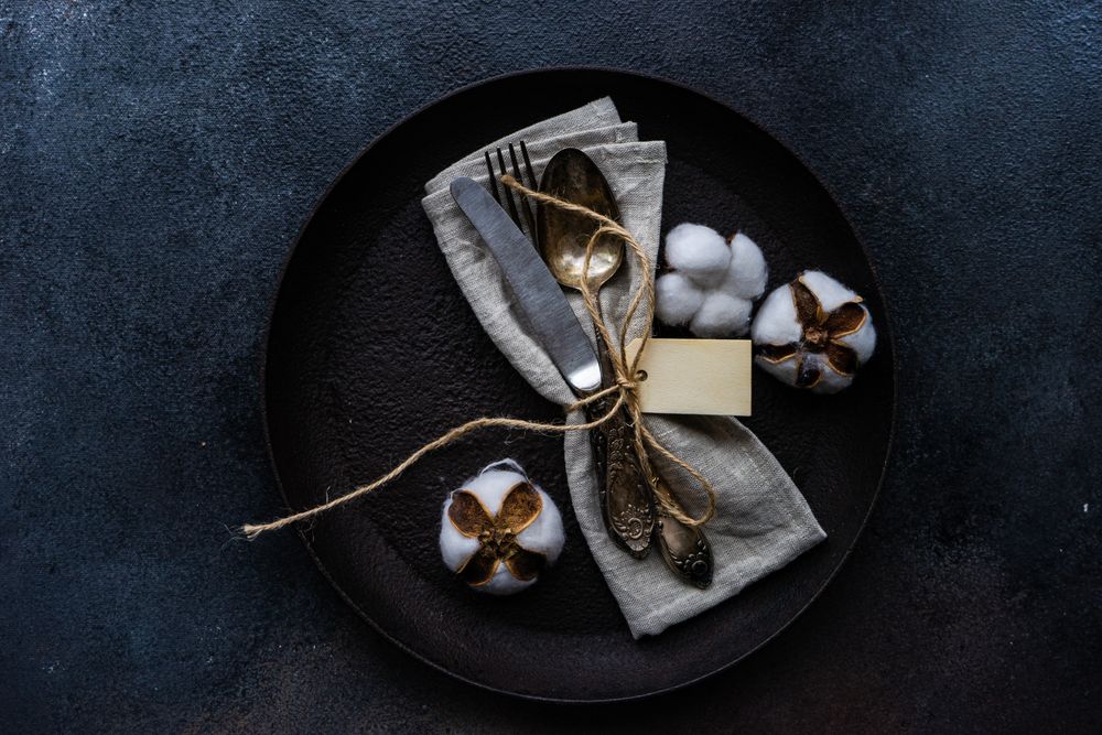 Top view of plate with decorative cotton and feathers with napkin with space for text