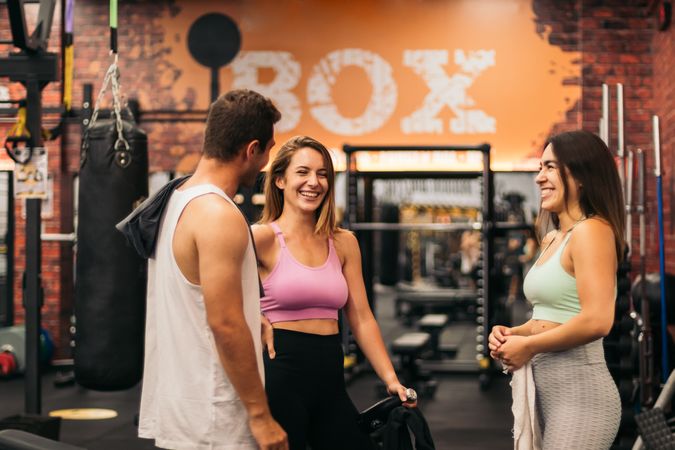 friends talking and having fun in the gym while they are resting