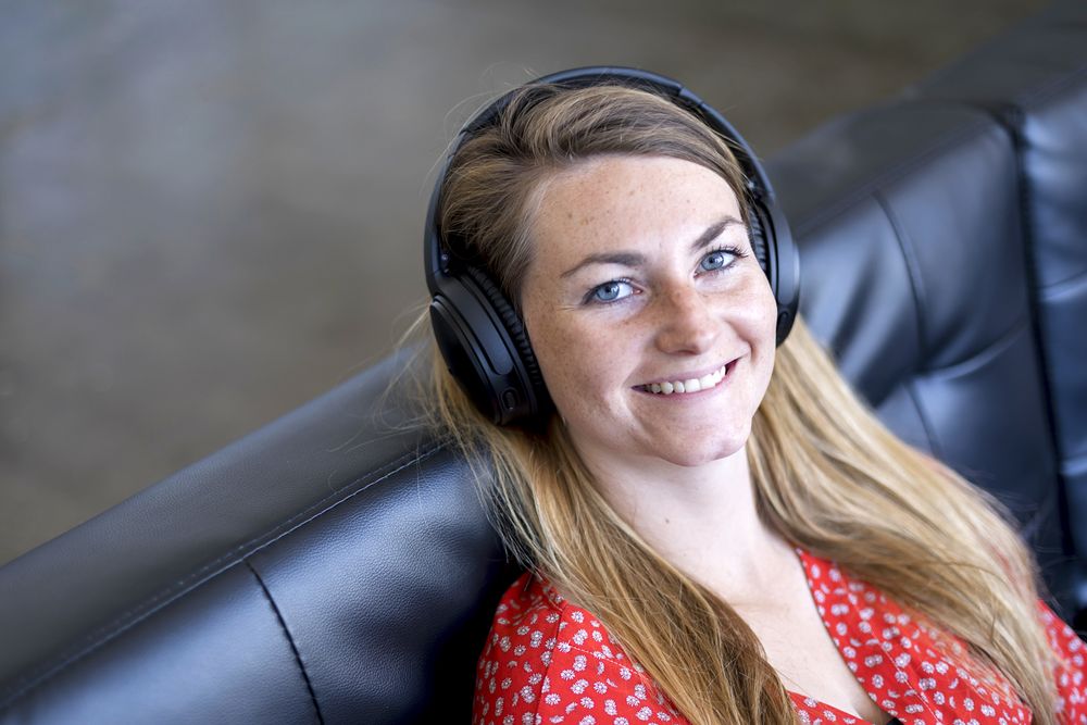 A head and shoulder shot of a woman looking into the camera wearing headphones