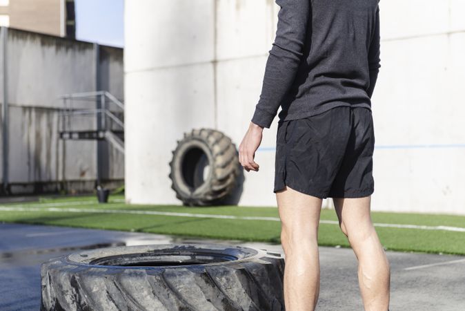Man training with tire on sports ground