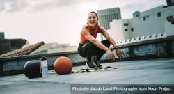 Fitness woman sitting on her toes while doing workout on rooftop 5pYVN4