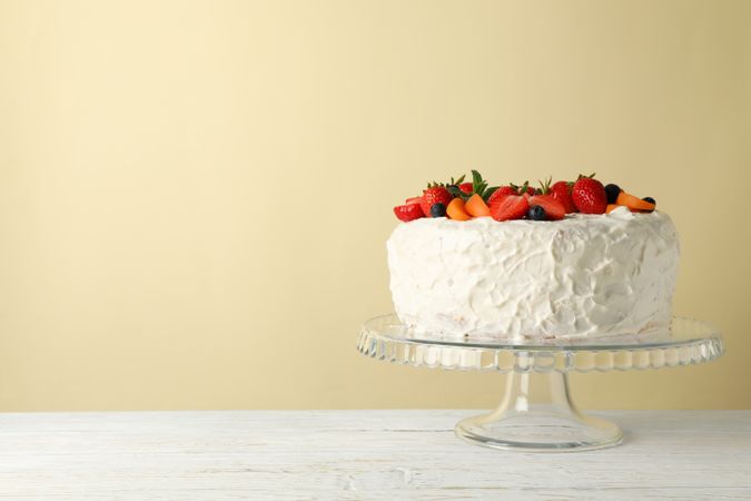Berry cream cake on wooden table. Delicious dessert