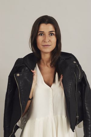 Serious pensive young female wearing leather jacket in studio