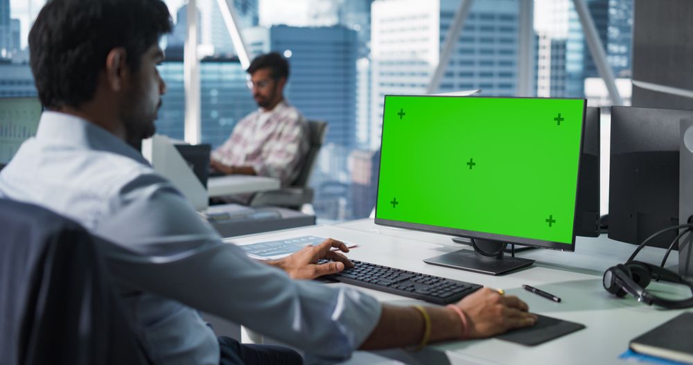 Indian Chief Financial Officer Working on Desktop Computer with Green Screen Mock Up Display.