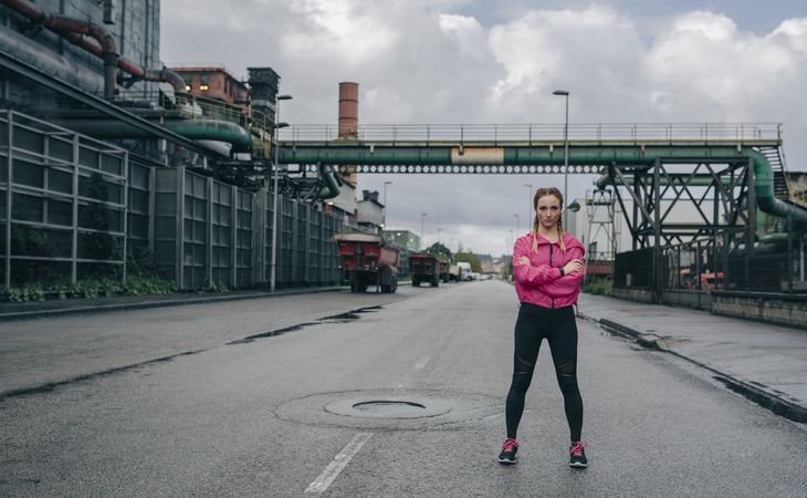 Sportswoman posing arms crossed in an industrial zone