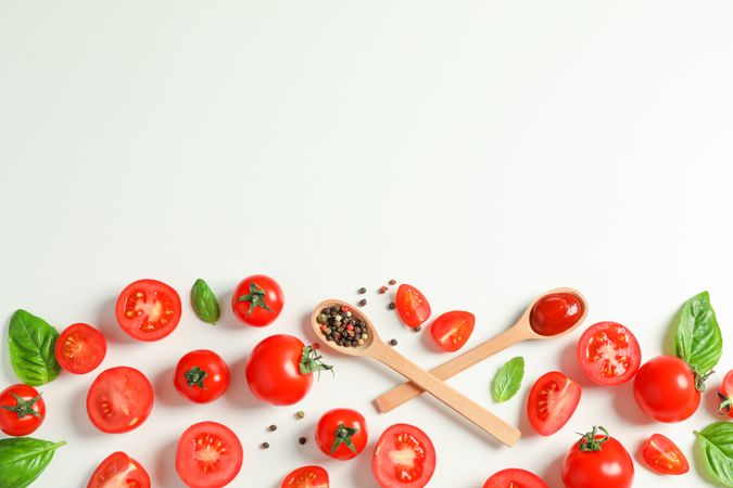 Flat lay composition with fresh tomatoes, pepper, basil and wooden spoons on plain background, space for text. Ripe vegetables