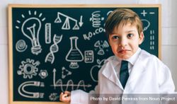 Child dressed as a scientist in front of chalkboard 0V6WpO