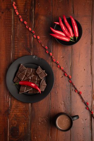 Hot beverage near plate with chocolate and pepper