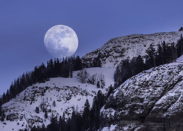 Stunning moonrise over snowing mountains in Yellowstone National Park
