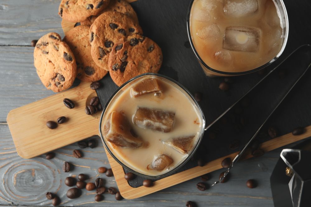 Composition with ice coffee and cookies on wooden background