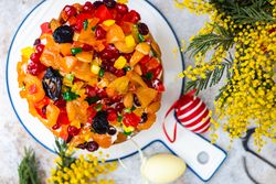 Top view of Easter food concept with traditional cake and colorful eggs decorated with spring flowers