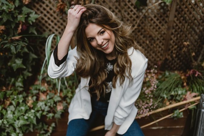 Woman sitting on planter in garden