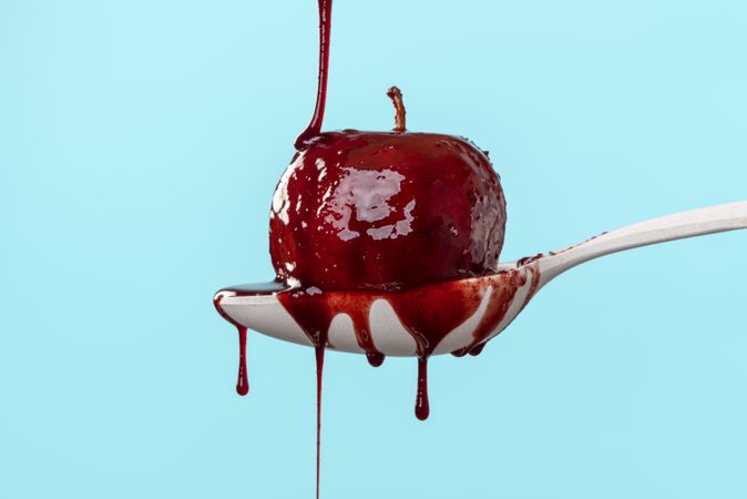 Baked apple covered in red wine sauce isolated on a blue background