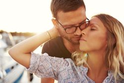 Couple kissing on a pier on a summer evening