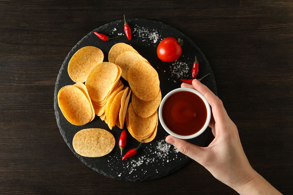 Potato chips in a bowl with chili pepper and sauce