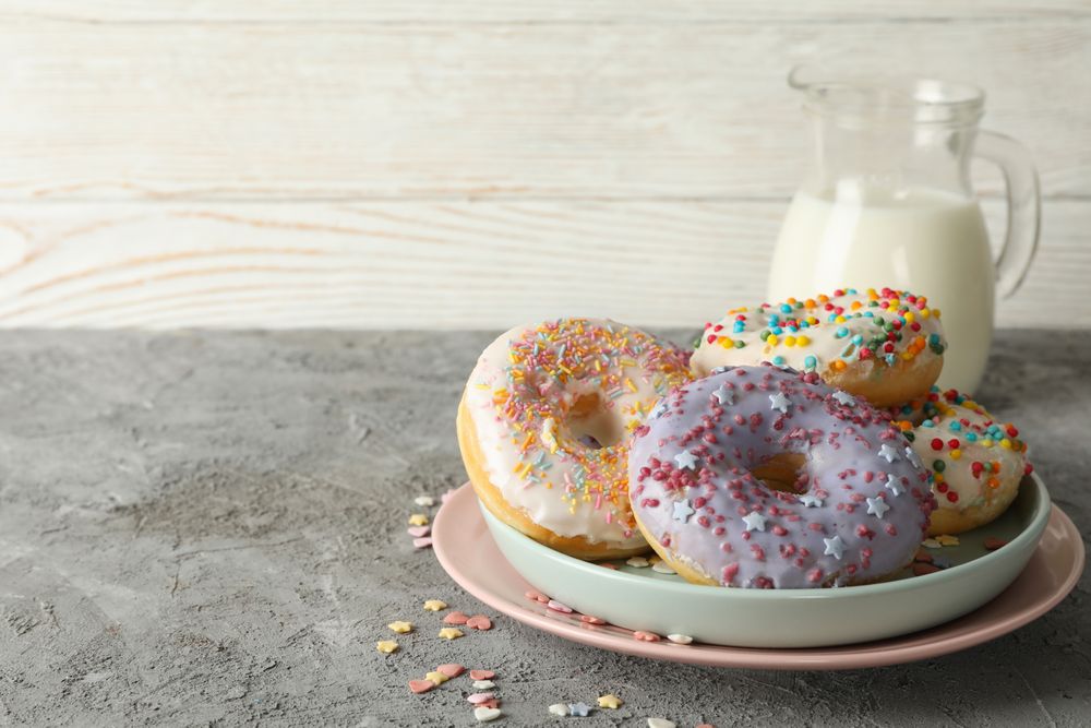 Concept of tasty food with donuts and milk on gray background