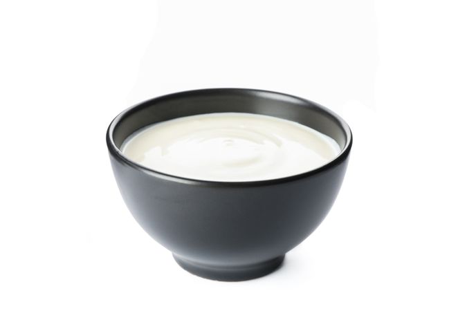 Bowl of sour cream yogurt isolated on neutral background