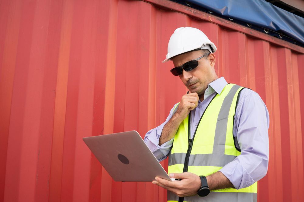Man with laptop working in logistic on shipping site
