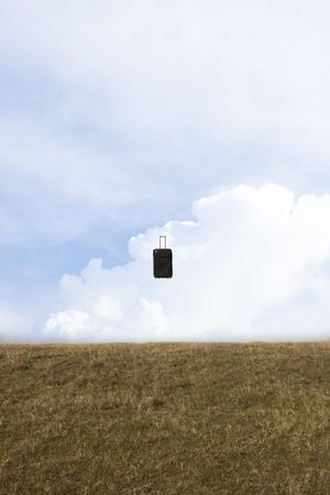 Suitcase suspended in air, vertical