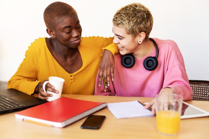 Two women studying with coffee and orange juice