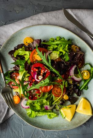 Organic vegetable salad with lemon wedges