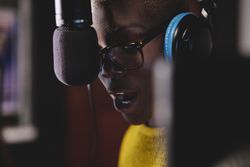 Pensive Black woman recording song
