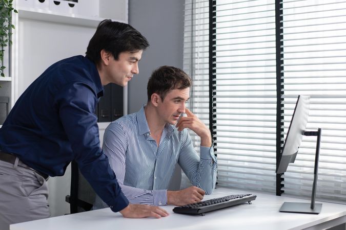 Coworkers talking together over screen in the workplace